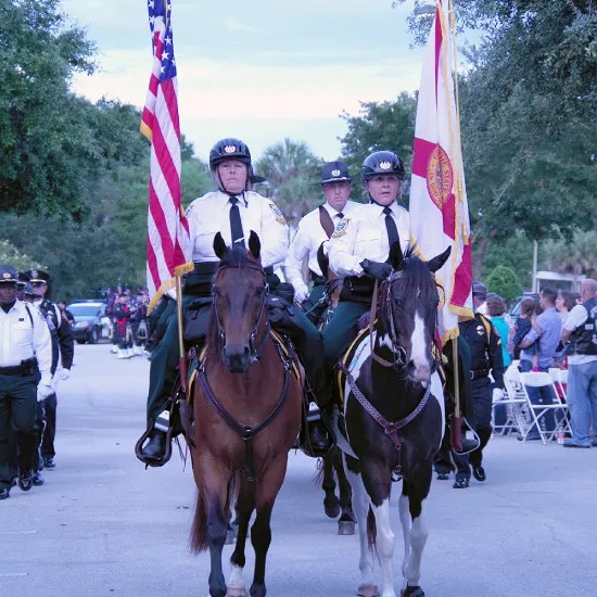 Mounted officers carrying flags in a parade
